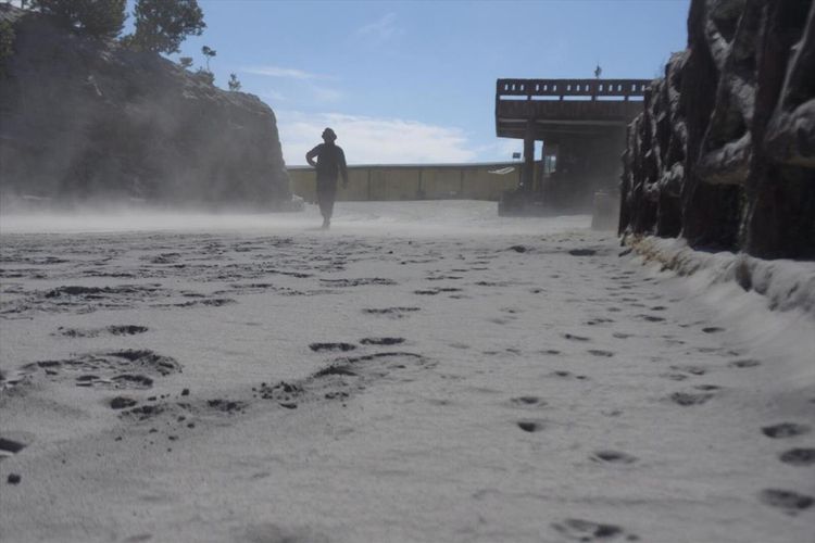 Seorang warga tampak berjalan di atas jalan yang dipenuhi debu vulkanik setebal kurang lebih 5 centimeter di Kawah Ratu, pusat wisata Gunung Tangkuban Parahu, pasca erupsi, Jumat (26/7/2019) kemarin. 