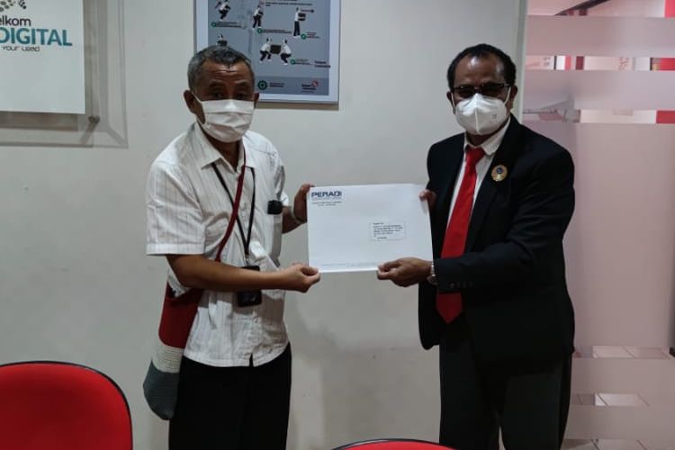 Ketua Peradi Papua, Anton Raharusun (kanan) menyerahkan surat somasi kepada GM Telkom Papua, Sugeng Widodo, Jayapura, Papua, Selasa (25/5/2021)