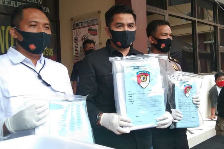 Kasat Reskrim Polres Karawang AKP Oliesta Ageng Wicaksana (tengah) menunjukkan barang bukti kasus penyelewengan dana PDAM Tirta Tarum saat konferensi pers di Mapolres Karawang, Rabu (12/8/2020).