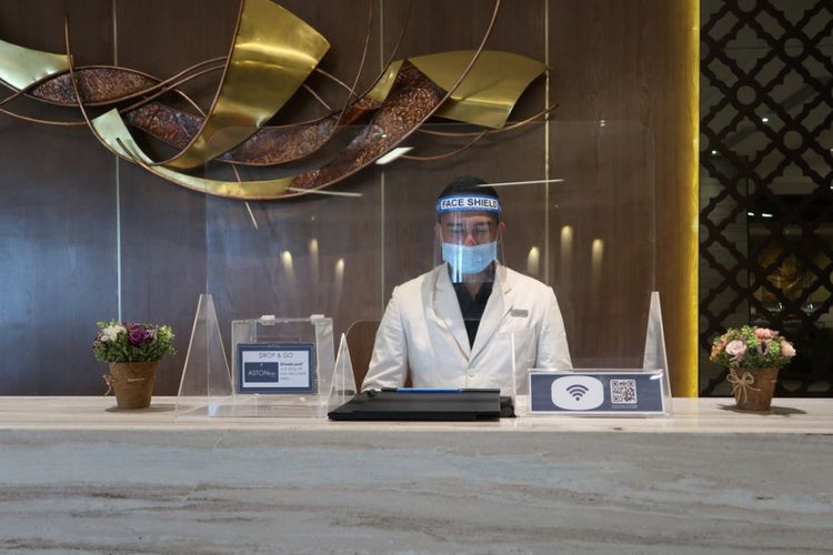 Resepsionis ASTON Inn Gresik dilengkapi face shield dan masker untuk menerima tamu hotel yang berkunjung.