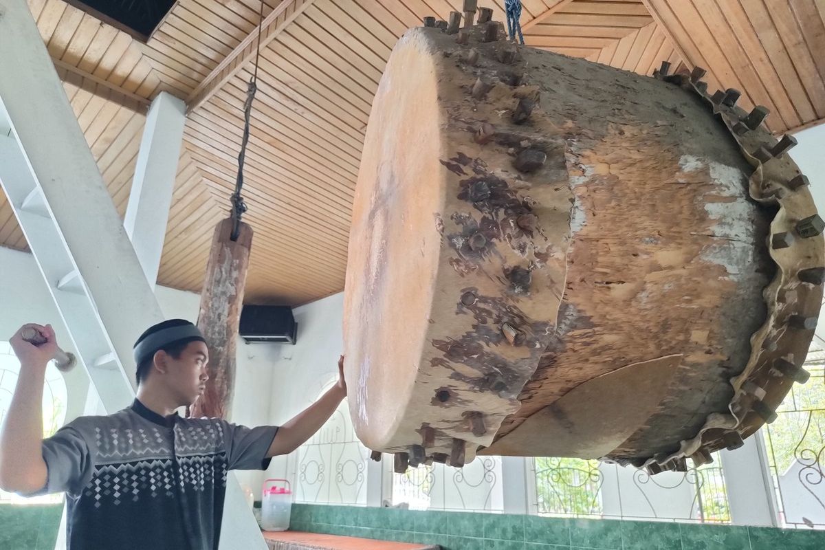 Gusnar Paloh tengah memukul beduk yang usianya lebih dari 100 tahun di masjid Almuttaqin Desa Yosonegoro menjelang salat. Struktur beduk ini terbuat dari kayu utuh dengan membran kulit sapi di kedua sisinya.