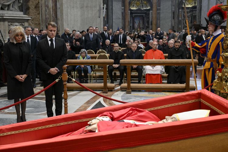 Presiden Perancis Emmanuel Macron (kedua dari kiri) dan istrinya, Brigitte (kiri), saat melihat jenazah Paus Fransiskus di Basilika Santo Petrus, Vatikan, Jumat (25/4/2025). Pemakaman Paus Fransiskus digelar pada Sabtu (26/4/2025).