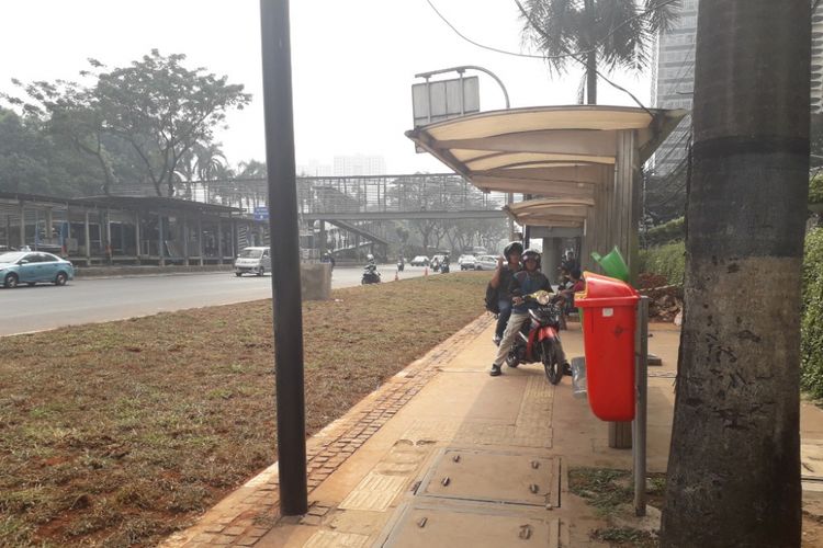 Halte bus di depan Gedung Graha CIMB Niaga, Jalan Jenderal Sudirman, yang aksesnya terhalang area rerumputan, Selasa (24/7/2018).