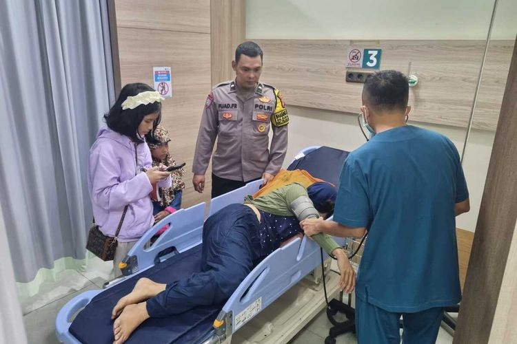 Dua anggota Polres Karawang menolong pemudik yang sakit, Kamis (11/4/2024).