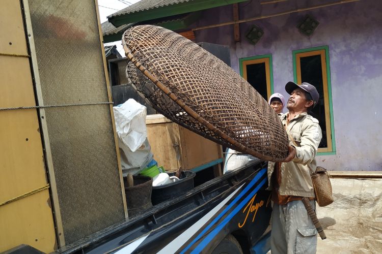 Seorang warga memindahkan perlengkapan rumah tangga ke mobil bak terbuka di Kampung Bojong, Desa Cicadas, Kecamatan Cisolok, Jawa Barat, Rabu (23/1/2019).