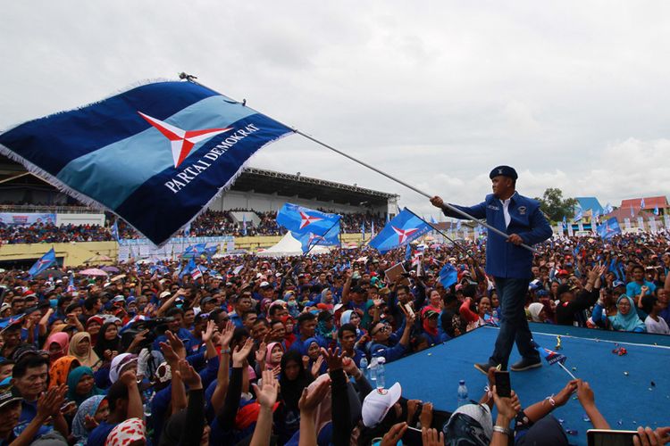 Ketua DPD Partai Demokrat Kalimantan Barat, Suryadman Gidot, mengibarkan Panji Demokrat dihadapan ribuan simpatisan masyarakat usai pelantikan di stadion Kridasana, Singkawang, Kalimantan Barat (17/9/2017