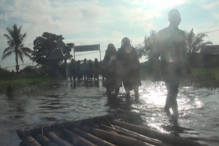 Siswa SMKN 1 Pemulutan Ogan Ilir Sumatera Selatan harus rela berjalan kaki menembus banjir untuk mencapai sekolah guna mengikuti Ujian Nasional Berbasis Komputer (UNBK).
