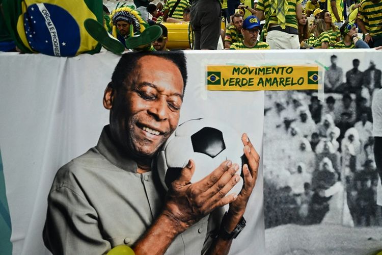 Legenda Brasil Pele ditampilkan di spanduk besar dekat kerumunan penonton saat pertandingan Grup G Piala Dunia 2022 Kamerun vs Brasil di Stadion Lusail, Qatar, 2 Desember 2022. Pele tengah menjalani perawatan di RS di Sao Paolo karena masalah pernapasan. Pele meninggal dunia dalam usia 82 tahun pada Jumat (30/12/2022) dini hari WIB.