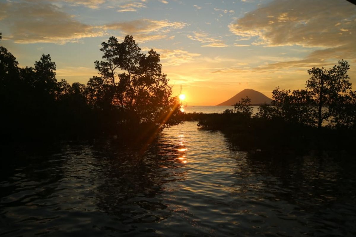 Indahnya matahari terbenam diantara mangrove dan Gunung Manado Tua dari ekowisata Mangrove Park Bahowo di Manado, Sulawesi Utara yang dikelola oleh Kelompok Mangrove Tongkena, Manado, Sulawesi Utara, Rabu (29/8/2018). 