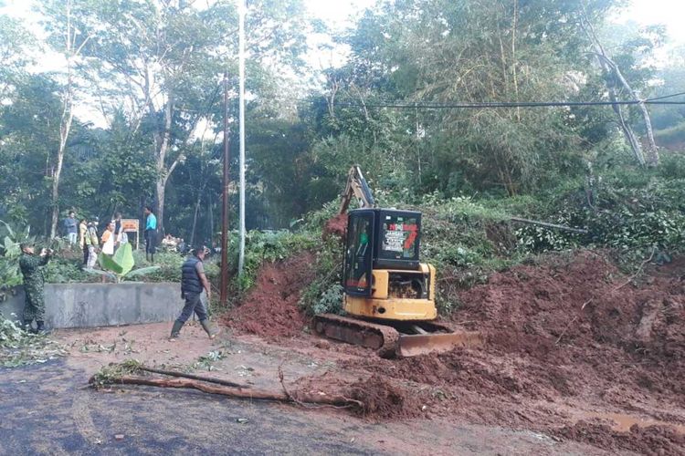 Alat berat sedang membersihkan jalur yang tertutup material tanah longsor di Hayawang, Desa Winduraja, Kecamatan Kawali, Kabupaten Ciamis, Kamis pagi (18/2/2021).