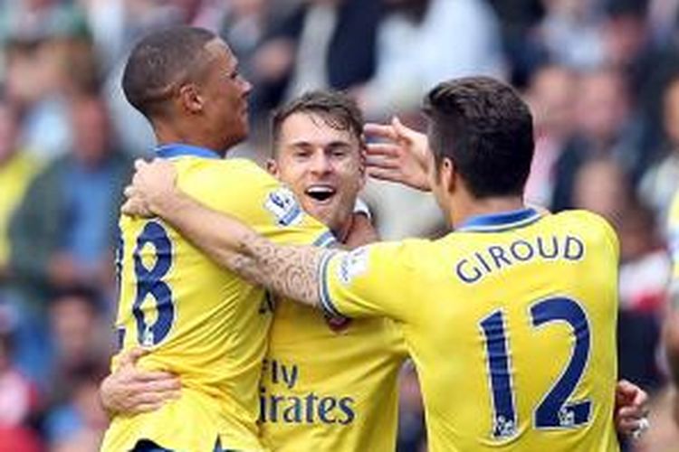 Kieran Gibbs (kiri) dan Olivier Giroud (kanan) ikut merayakan keberhasilan Aaron Ramsey (tengah) mencetak gol pertamanya (dari dua) ke gawang Sunderland, pada lanjutan Premier League, di Stadium of Light, Sabtu (14/9/2013).