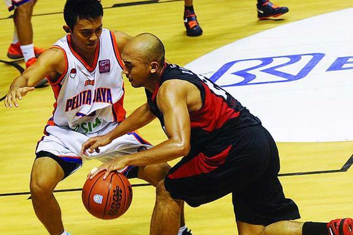 Pemain Bimasakti Nikko Steel, Bima Risky Ardiansyah (kanan), berusaha melewati pemain Pelita Jaya Esia, Gian Gumilar, dalam Flexi NBL Indonesia Seri V di DBL Arena Surabaya, Jawa Timur, Senin (12/3). Pelita Jaya Esia menang 84-59.