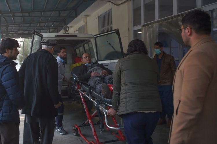Warga membantu korban luka akibat serangan bersenjata turun dari ambulans, usai penyerangan di sebuah gedung pemerintahan di Kabul, Afghanistan, Senin (24/12/2018).