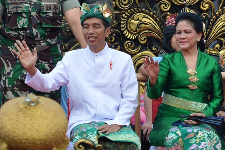 Presiden Joko Widodo (kiri) didampingi Ibu Negara Iriana Joko Widodo melambaikan tangan ketika mengikuti Pawai Pesta Kesenian Bali ke-40 di Denpasar, Bali, Sabtu (23/6/2018). Pesta Kesenian Bali yang mengangkat tema Teja Dharmaning Kauripan, Api Spirit Penciptaan menampilkan berbagai kesenian dari perwakilan dari Pemerintah Provinsi Bali, sembilan kabupaten/kota di Bali, sejumlah universitas di Bali serta peserta dari luar negeri dan berlangsung 23 Juni-21 Juli 2018.