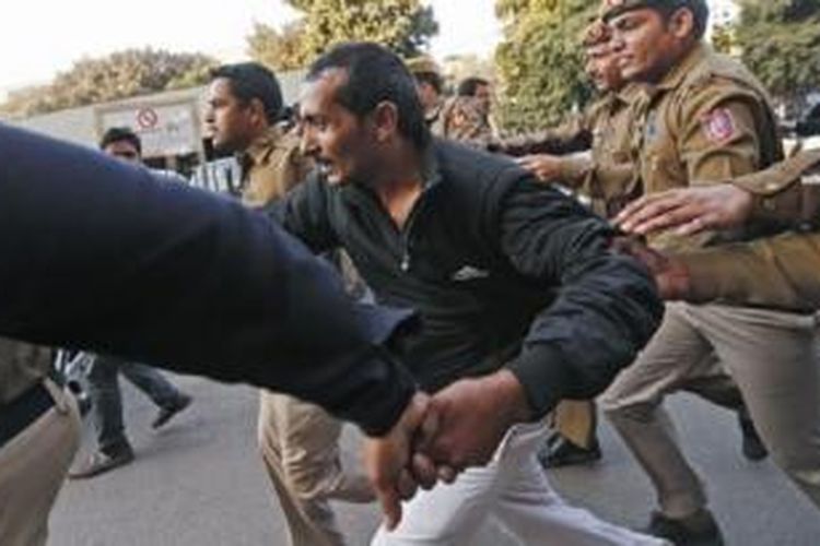 Polisi India mengamankan Shiv Kumar Yadav (tengah, baju hitam) dari amukan massa, setelah keluar dari pengadilan di New Delhi 