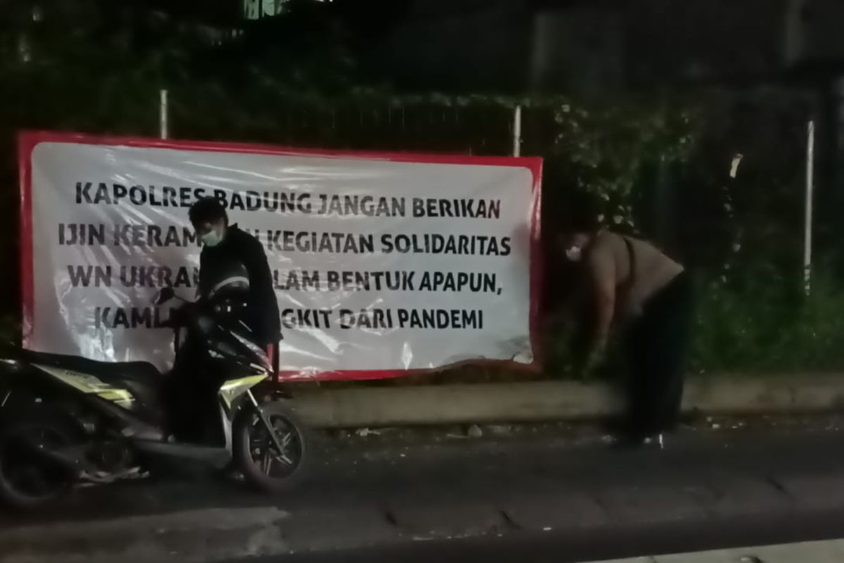 Petugas saat hendak menurunkan salah satu spanduk yang memuat larang aksi damai WN Ukraina./Dok.Satpol PP Badung. 