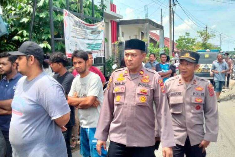 Kapolsek Banda Sakti, Iptu Faisal, memimpin evakuasi wanita berinisial E (35) warga Kecamatan Dewantara, Kabupaten Aceh Utara, Provinsi Aceh, dikepung warga di Desa Pusong, Kecamatan Banda Sakti, Kota Lhokseumawe, Selasa (14/2/2023). Pasalnya, warga mengira wanita penderita epilepsi ini sebagai pelaku penculikan anak. Isu penculikan anak sedang santer beredar di masyarakat dua pekan terakhir.