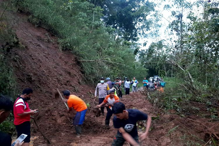 Warga dan aparat terkait melakukan pembersihan jalan dari material tanah yang longsor di Desa Sidorejo, Kecamatan Doko, Kabupaten Blitar, Kamis (18/11/2021) sore