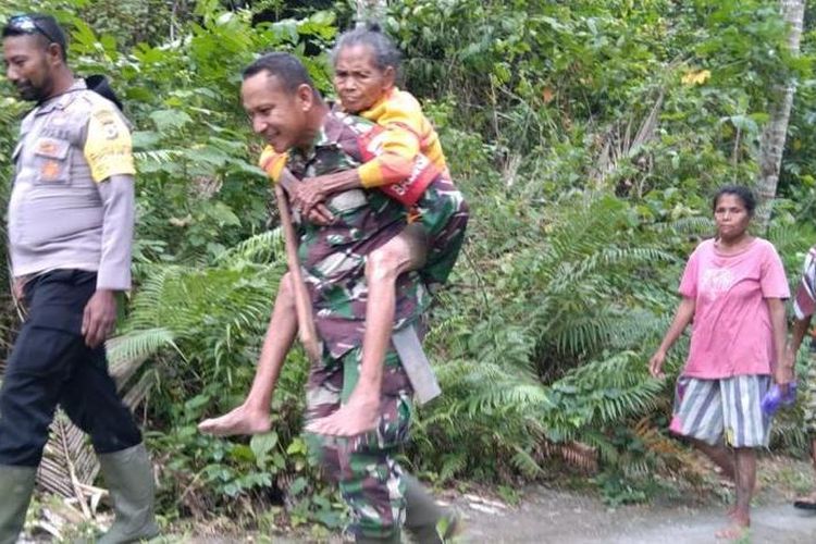 Bintara Pembina Desa (Babinsa) desa Alusi Kelaan, Kabupaten Kepulauan Tanimbar Maluku menggendong seorang nenek berusia 87 tahun menuju desa, Rabu (27/7/2022). Nenek ini sebelumnya hilang tiga hari lalu saat pergi ke kebun