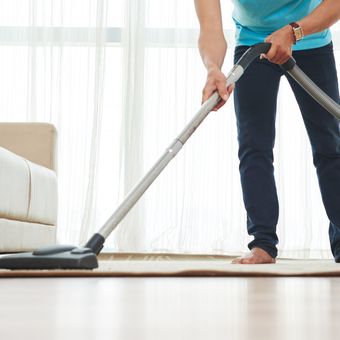 Ilustrasi menggunakan vacuum cleaner untuk membersihkan karpet.