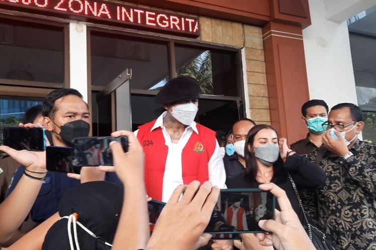 Musisi I Gede Ari Astina terlihat mengenakan rompi tahanan berwarna merah saat keluar dari Kantor Kejaksaan Negeri Jakarta Pusat dan akan dibawa ke rutan Polda Metro Jaya.