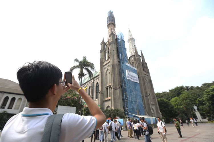 Seorang siswa sekolah menengah mengambil foto di sela mengikuti acara Wisata Rumah Ibadah saat mengunjungi Gereja Katolik Katedral, Jakarta, Kamis (15/6/2017). Acara berlangsung selama satu hari dengan melakukan perjalanan ke rumah ibadah lima agama di Jakarta, bertujuan menyebarkan semangat perdamaian dan toleransi di Indonesia melalui anak-anak.