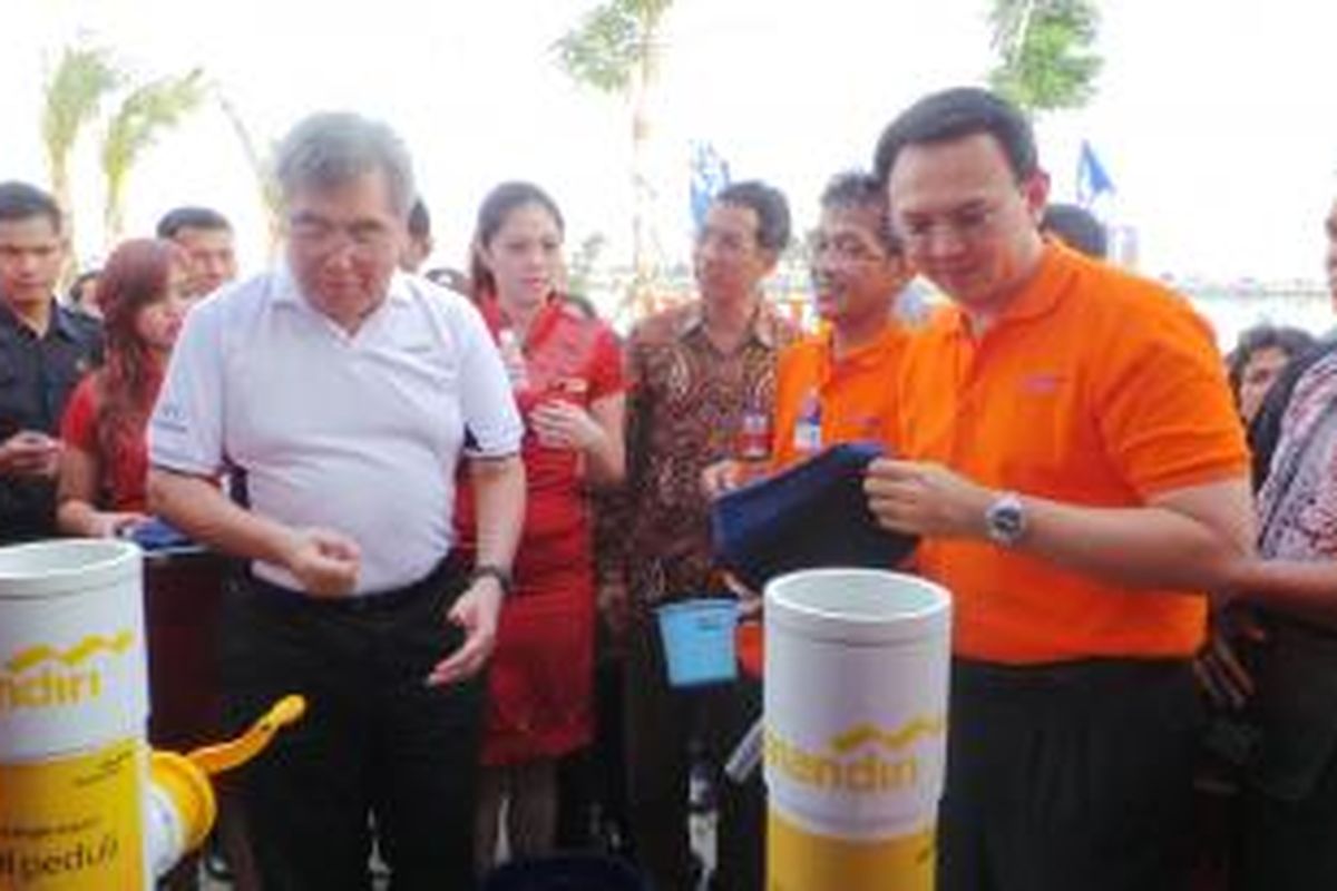 Wakil Gubernur DKI Jakarta Basuki Tjahaja Purnama bersama Wakil Direktur Utama Bank Mandiri Riswinandi saat pemberian bantuan kepada korban banjir, di Waduk Pluit, Jakarta, Kamis (30/1/2014).