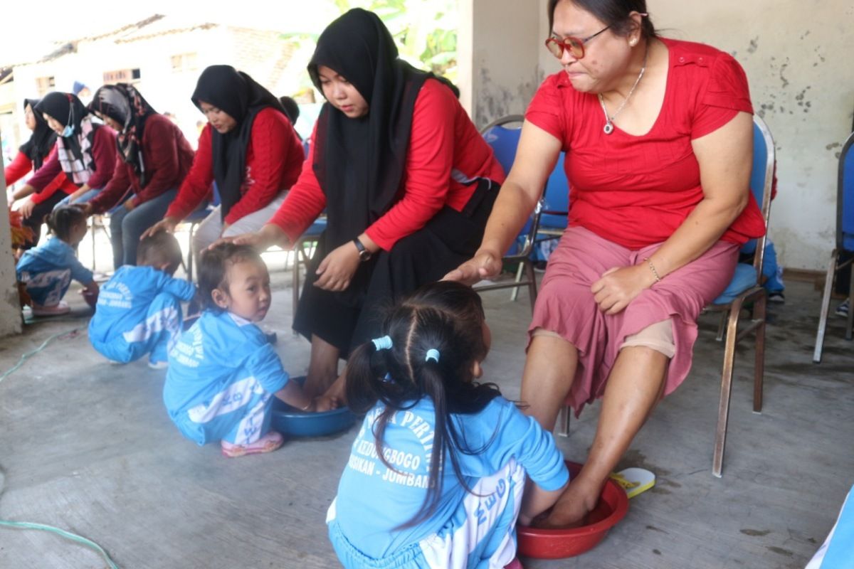 Momen saat anak-anak PAUD dan Kelompok Belajar membasuh kaki ibunya di kawasan Wisata Edukasi Ngusikan (Wedang) di Desa Ngusikan, Kecamatan Ngusikan, Kabupaten Jombang, Jawa Timur, Rabu (22/12/2022).