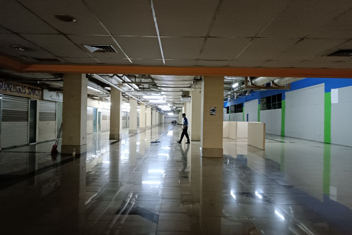 Seorang office boy (OB) tampak membersihkan area lantai 1 di Grand Serpong Mal yang sunyi pada Rabu (14/12/2022). 