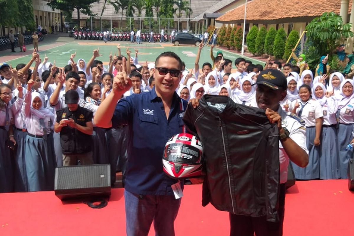 Head of Marketing PT Wahana Makmur Sejati Ario, saat memberikan hadiah berupa helm, jaket, dan sarung tangan kepada Slamet Gunaedi, di SMAN 4 Tangerang Selatan, Senin (4/2/2019)