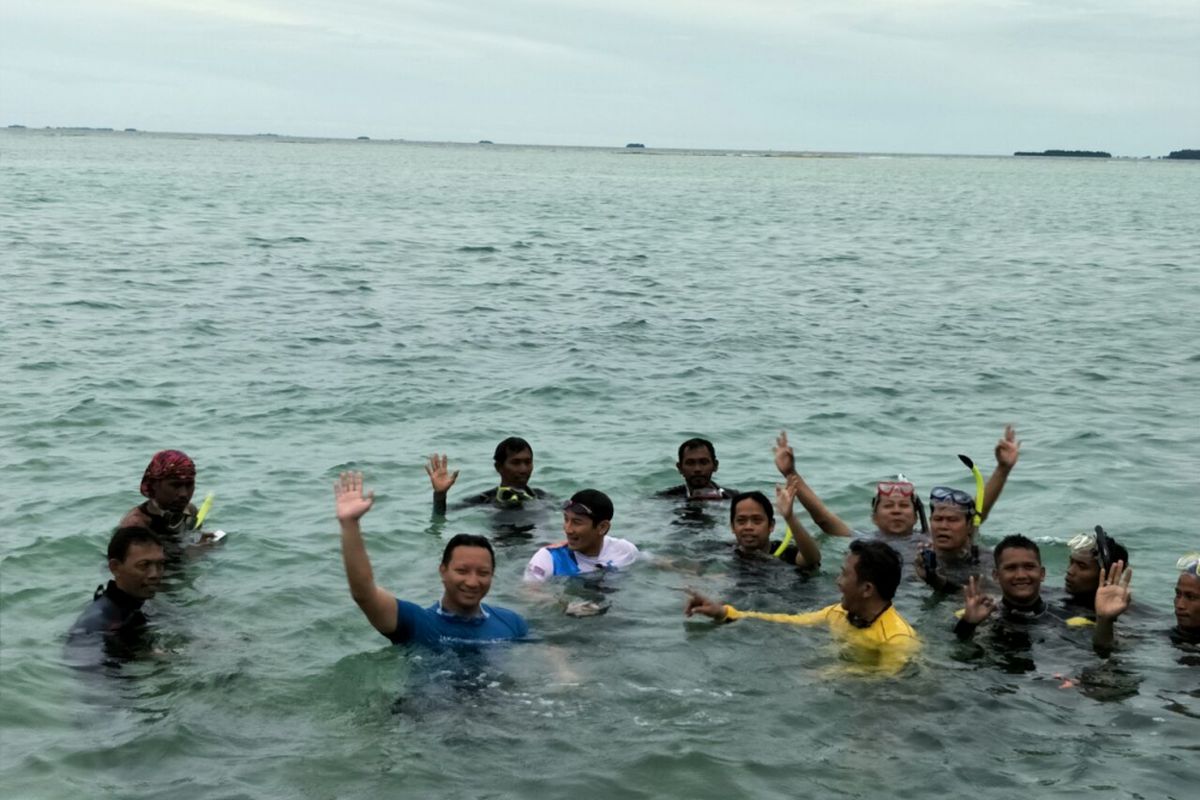 Wakil Gubernur DKI Jakarta Sandiaga Uno berenang di sekitar Jembatan Cinta, Pulau Tidung, Selasa (27/2/2018). 