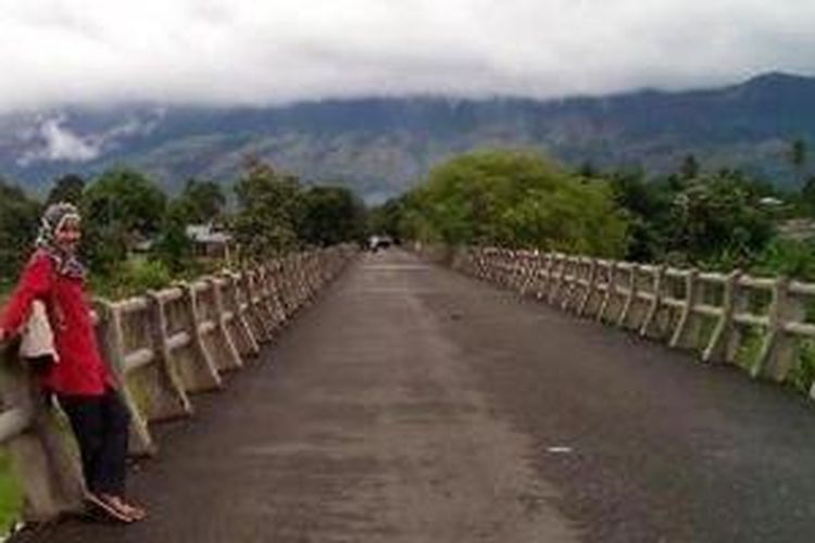 Jembatan menuju gapura masuk desa wisata Lubuk Sukon, Kecamatan Ingin Jaya, Kabupaten Aceh Besar, Aceh. Dari kejauhan tampak gugusan Bukit Barisan.