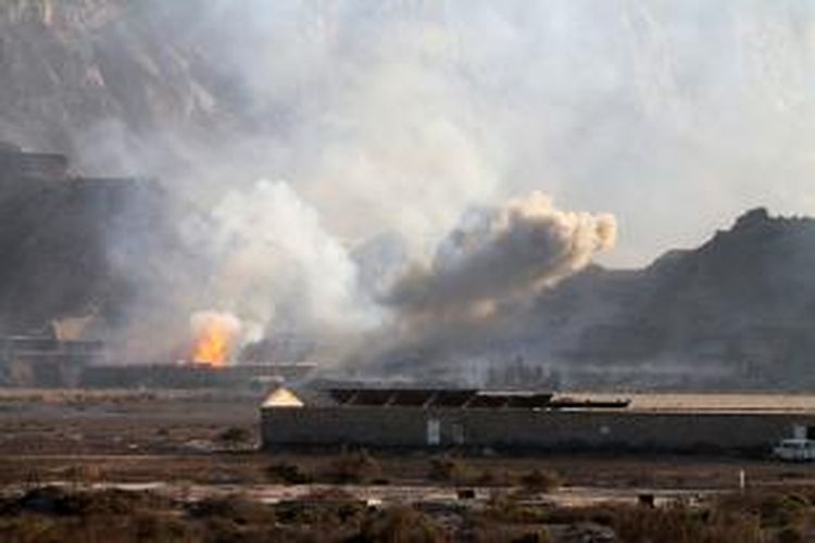 Kilatan api dan asap terlihat dari gudang senjata yang meledak di kota Aden, Yaman, Sabtu (28/3/2015).