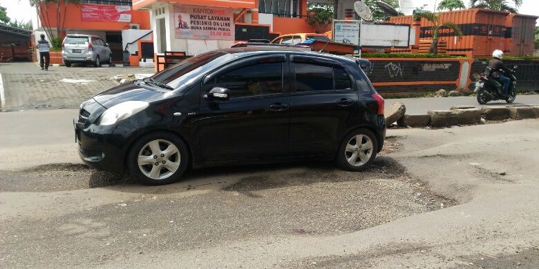 Kondisi Jalan Raya Jakarta-Bogor di Perempatan Gaplek, Tangsel yang penuh lubang. Semua kendaraan melambat untuk menghindari lubang-lubang berdiameter 20-30 cm dengan kedalaman 10-20 cm. Foto diambil Selasa (30/1/2018).