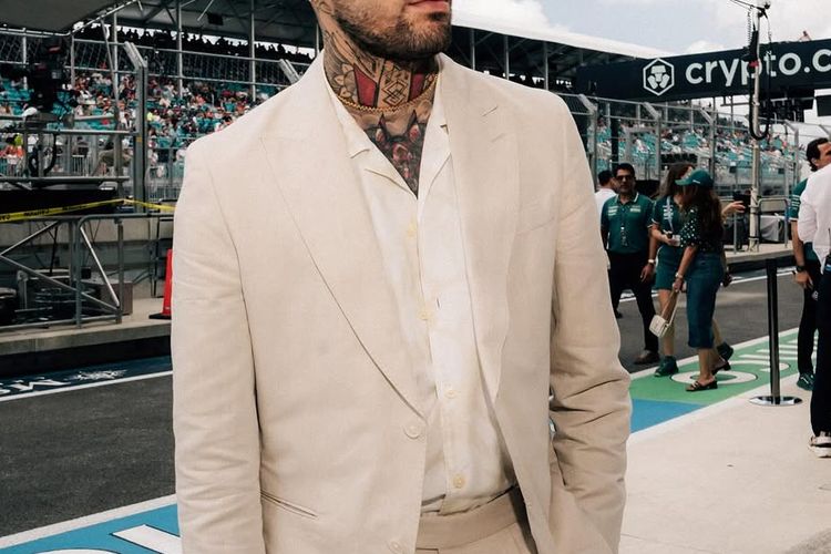 Zayn Malik mengenakan blazer dengan kemeja putih.