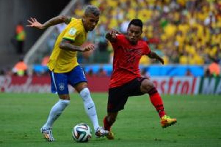 Bek Brasil, Dani Alves (kiri), mendapat pengawalan pemain Meksiko, Jose Juan Vazquez (kanan), pada laga Grup A Piala Dunia 2014 di Estadio Castelao, Fortaleza.