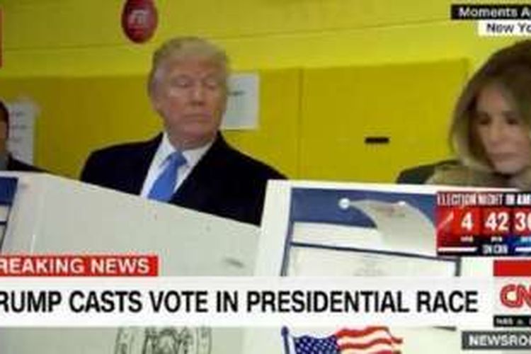 Calon Presiden  Partai Republik Donald Trump terlihat mengintip istrinya Melania Trump yang sedang memberikan suara