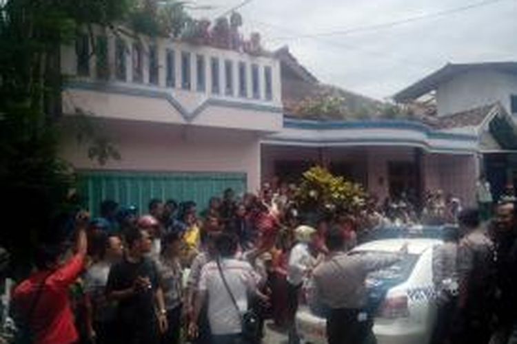 Warga meneriaki tersangka pembunuh seorang janda anak dua saat rekonstruksi berlangsung di Kota Kediri, Jawa Timur, Kamis (20/3/2014).