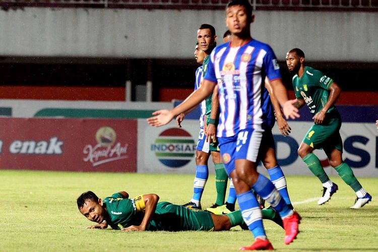 Pemain Persebaya Surabaya Arif Satria terjatuh seusai duel dengan pemain Persiraja Banda Aceh saat pertandingan pekan 10 Liga 1 2021-2022 yang berakhir dengan skor 2-0 di Stadion Maguwoharjo Sleman, Minggu (31/10/2021) malam.