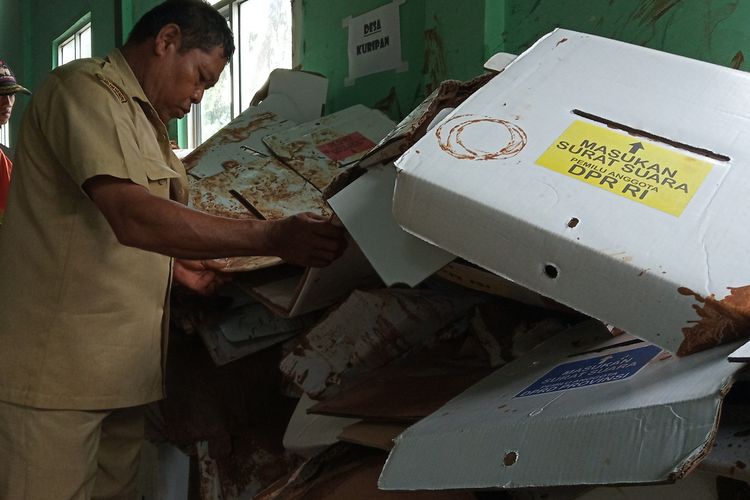 Sejumlah petugas sedang mengevakuasi kotak suara yang rusak akibat hujan deras di Desa Cibentang, Kecamatan Ciseeng Kabupaten Bogor, Senin (15/4/2019)