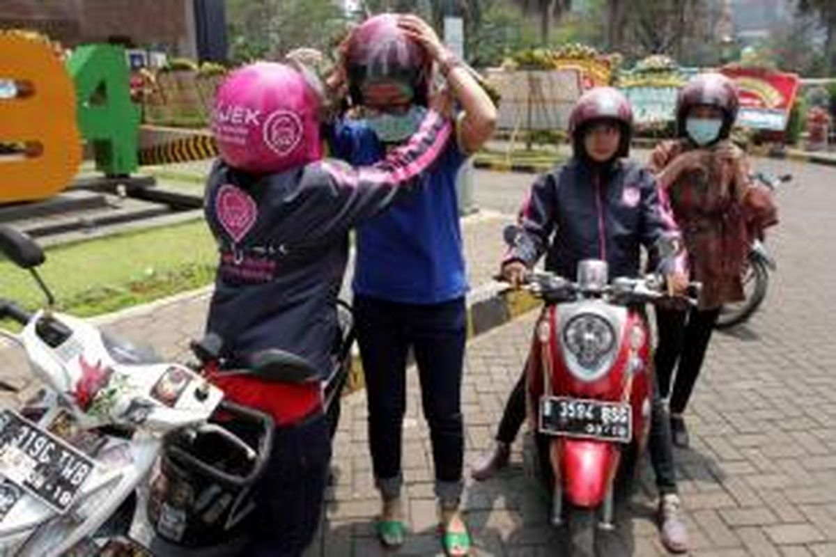 Vice President Corporate Communication XL, Turina Farouk (biru) bersama salah seorang founder LadyJEK, Lucia (kanan) mencoba layanan transportasi ojek khusus untuk wanita LadyJEK, di Jakarta Selatan, Jumat (9/10/2015).