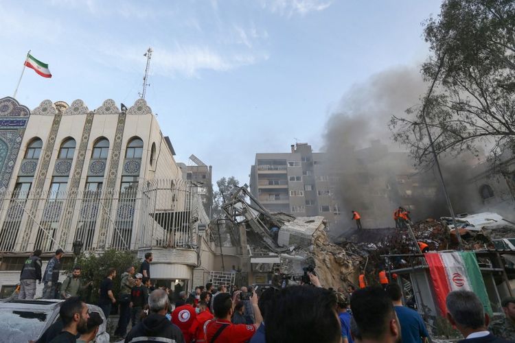 Personil darurat dan keamanan mencari puing-puing di lokasi serangan yang menghantam gedung yang terhubung dengan kedutaan Iran di ibu kota Suriah, Damaskus, pada 1 April 2024.