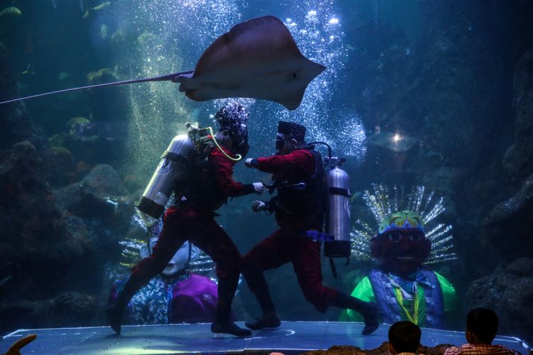 Dua penyelam sebagai tokoh Pitung memperagakan jurus-jurus silat di akuarium Seaworld, Taman Impian Jaya Ancol, Jakarta Utara, Jumat (22/6/2018). Pertunjukkan spesial yang bernama Ondel-ondel Underwater disiapkan Seaworld Ancol dalam rangka memeriahkan HUT DKI Jakarta yang memasuki usia ke-491.