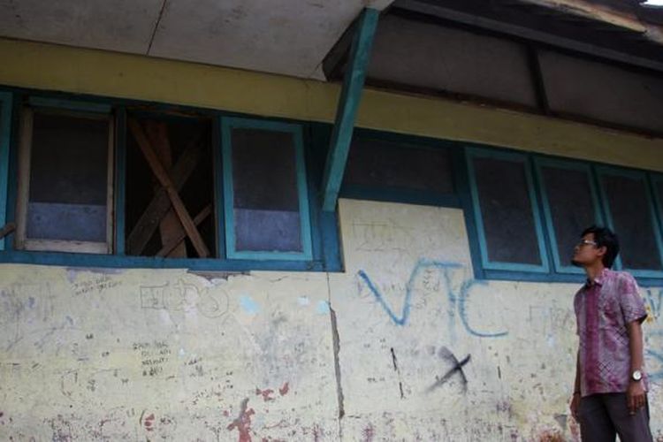 Seorang guru berdiri di samping dua ruang kelas SDN 2 Trusmi Wetan, Kecamatan Plered, Kabupaten Cirebon, Jawa Barat Kamis (9/2/2017). Plafon rusak, atap rapuh, kaca dan kayu ventilasi yang sudah dirayap, memaksa guru memindahkan murid belajar di ruang lain. Mereka berharap pemerintah segera membantu memperbaiki demi keamanan dan kenyamanan belajar. Sekolah Dasar Negeri ini terletak di tengah kawasan pusat industri batik trusmi. 
