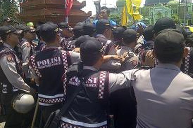 Polisi menahan massa mahasiswa yang mengancam akan masuk gedung DPRD Jatim.