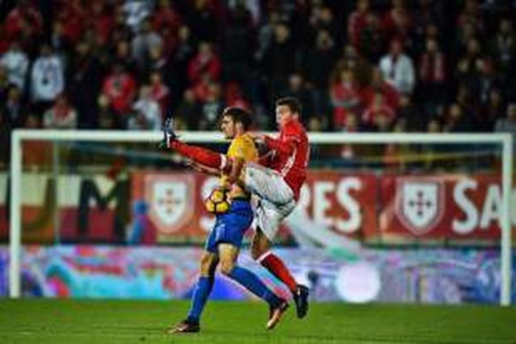 Bek Benfica, Victor Lindelof (merah), berduel dengan pemain Estoril, Afonso Taira, pada pertandingan Liga Portugal, Sabtu (17/12/2016).  