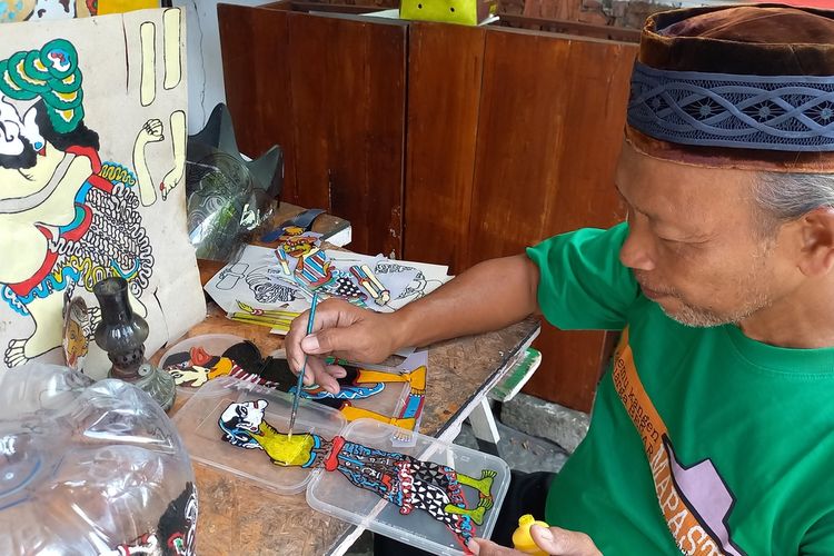 Iskandar saat memotong mengecat Wayang Uwuh yang terbuat dari Plastik, Jumat (13/1/2023)