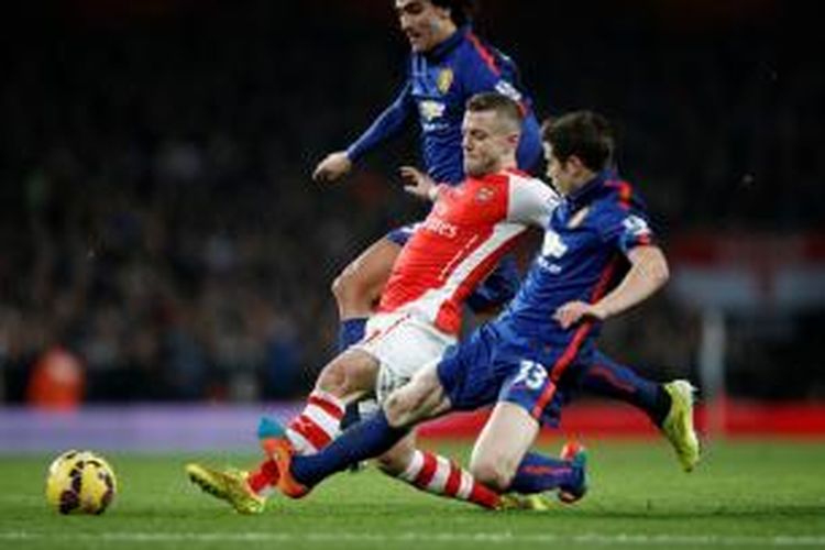 Gelandang Arsenal, Jack Wilshere, saat berusaha merebut bola dengan pemain Manchester United pada pertandingan lanjutan Premier League di Stadion Emirates, Sabtu (22/11/2014). 