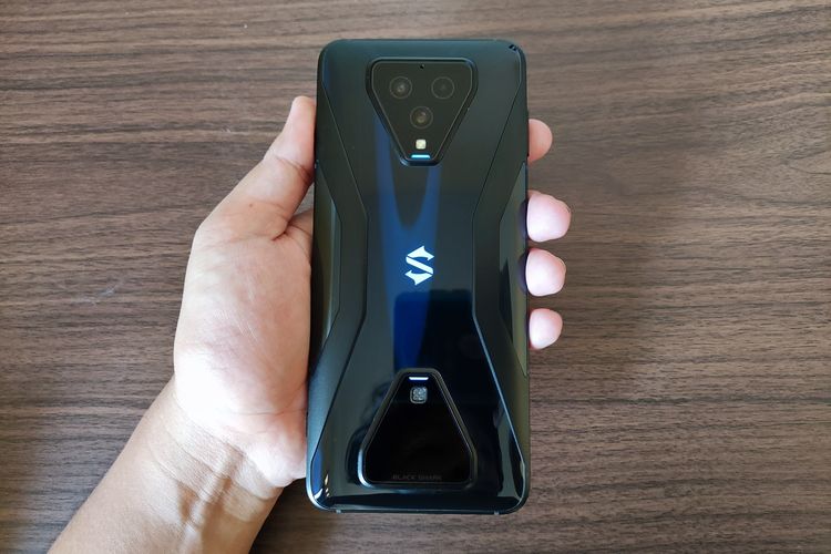 Tampilan punggung Black Shark 3. Bagian punggung ponsel gaming ini lebih kece. DI bagian atasnya ada modul segitiga yang menampung tiga kamera belakang (64 MP + 13 MP + 5 MP) dan modul magnetic charging. Ada pula lampu RGB huruf S di bagian tengahnya. Di atas kertas, bobot Black Shark 3 tercatat di angka 222 gram, dengan dimensi ketebalan 10,4 mm. Untuk sekelas ponsel gaming, ponsel ini cukup ringan untuk dibawa-bawa.