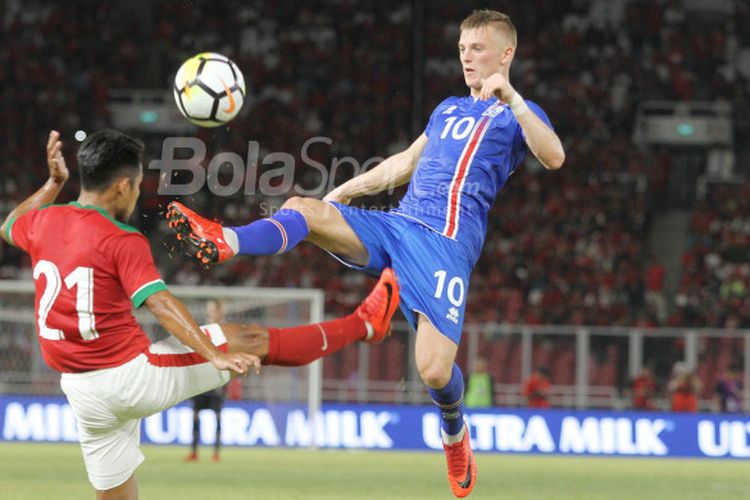 Pemain timnas Indonesia, Andik Vermansah, berduel dengan pemain timnas Islandia, Albert Gudmundsson, pada laga uji coba internasional di Stadion Utama GBK, Jakarta Selatan, Minggu (14/1/2018) malam.